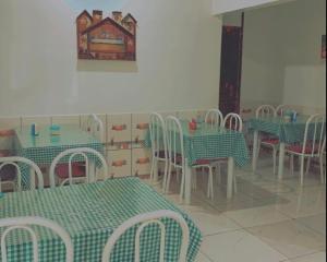 博阿维斯塔Hotel Maracá的一间设有绿色和白色桌椅的用餐室