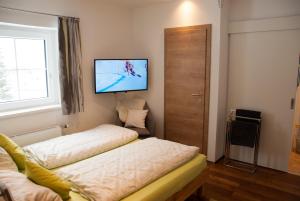 多内尔斯巴赫瓦尔德Ferienwohnung Mörsbachblick的客房设有两张床和一台墙上的电视。