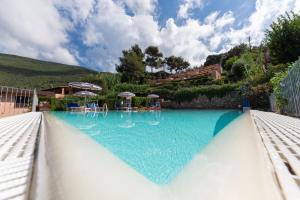 尼斯波特Vistamare La Fonte的一座带蓝色水和遮阳伞的大型游泳池