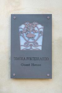 拉奎拉Dimora Fortebraccio的墙上的旅馆标志