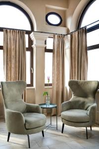 拉奎拉Dimora Fortebraccio的客厅配有两把椅子和一张桌子