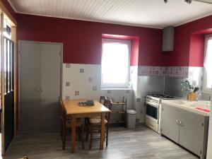 德沃吕伊Maison campagne au col du festre的厨房设有红色的墙壁和木桌