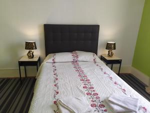 里斯本塞纳里奥卡迪塔旅舍的一间卧室配有一张大床,桌子上放着两盏灯