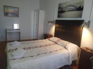 里斯本塞纳里奥卡迪塔旅舍的一间卧室配有一张带白色床罩的床