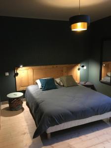 ChamblesEss'folie Gîte的一间卧室配有一张带蓝色棉被的大床