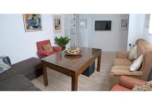 格拉纳达LA CASA DE LOS PINTORES, junto al centro de Granada的客厅配有咖啡桌和沙发