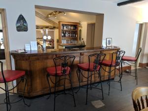 埃夫伯里Elderbrook House的一间酒吧,配有红色的椅子和木台面