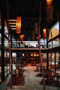 图卢姆Our Habitas Tulum的餐厅设有桌椅和吊灯。