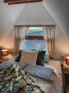 埃格尔Eged Cottage的一间卧室设有一张大床和大窗户