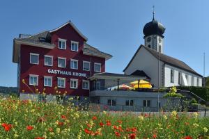 ZuckenrietGasthaus Krone Lenggenwil的花田中一座建筑,有灯塔