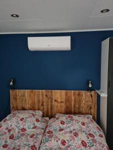 雷讷瑟De Stoof, complete studio voor 2 personen的一间卧室配有一张蓝色墙壁的床