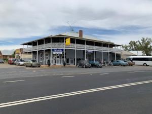 KoorawathaHotel Koorawatha的街道前有车辆停放的建筑物