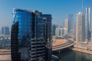 迪拜Radisson Blu Hotel, Dubai Canal View的市中心的高玻璃建筑