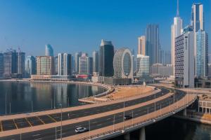 迪拜Radisson Blu Hotel, Dubai Canal View的一座城市,一座河流上的桥梁和建筑物