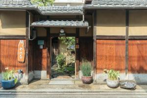 京都十四春旅馆的门前有盆栽植物的建筑