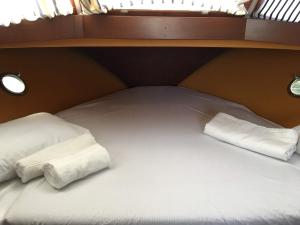 巴达洛纳Home Boat的一张位于房间的床,上面有两个枕头