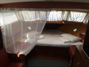 巴达洛纳Home Boat的小房间的小床,带窗帘
