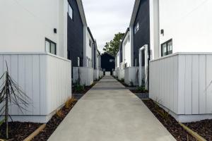 基督城Armagh 221 - Christchurch Holiday Homes的两座白色建筑之间的人行道