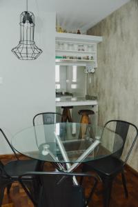 科尔多瓦Departamento centro Cordoba capital的一张带黑色椅子的玻璃桌和厨房