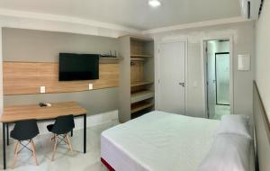 邦比尼亚斯Residencial Batista的一间卧室配有一张床和一张带两把椅子的桌子