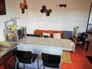 奥比多斯Óbidos - Casa do Castelo的厨房配有带椅子的柜台和沙发