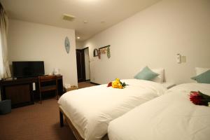 东京Okubo Hotel Hawaii的酒店客房设有两张床和电视。