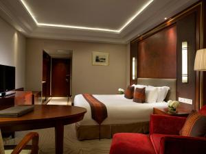 杭州杭州索菲特西湖大酒店的酒店客房设有一张大床和一张书桌。