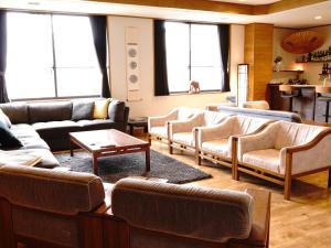 妙高雷弗利酒店的带沙发和桌子的客厅以及窗户。