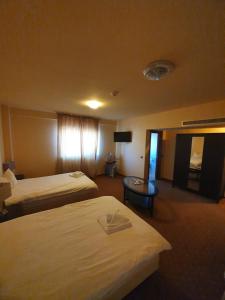 GherlaMerion的酒店客房设有两张床和一张桌子。