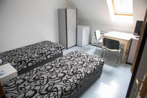 考波什堡Éva Vendégház的小房间设有两张床、一张桌子和一台电脑