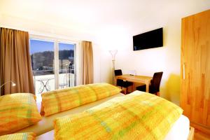 苏西德拉加勒酒店 的酒店客房设有两张床、一张桌子和一个窗户。