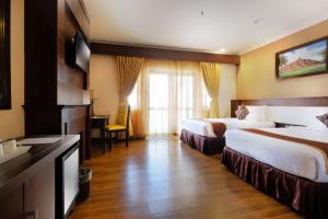 日惹皇家大摩玛丽欧波罗酒店的酒店客房配有两张床和一张书桌