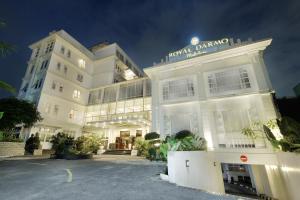 日惹皇家大摩玛丽欧波罗酒店的一座白色的建筑,前面设有停车场