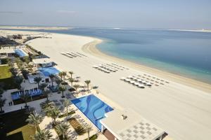 迪拜Riu Dubai Beach Resort - All Inclusive的享有海滩的空中景致,设有游泳池和椅子