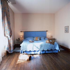 吕萨克莱沙托欧瑞芝斯酒店的一间卧室配有一张带蓝色床罩的床
