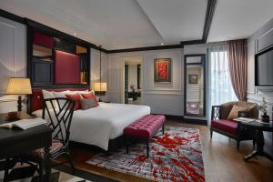 河内Aira Boutique Hanoi Hotel & Spa的一间卧室配有一张大床和一张桌子及椅子