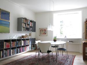 哥本哈根ApartmentInCopenhagen Apartment 701的用餐室配有桌椅和书架