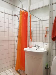 哥本哈根ApartmentInCopenhagen Apartment 931的浴室设有橙色淋浴帘,位于水槽旁