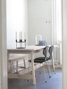哥本哈根ApartmentInCopenhagen Apartment 1141的一张带两把椅子和蜡烛的白色桌子