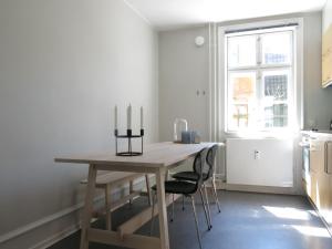 哥本哈根ApartmentInCopenhagen Apartment 1141的厨房配有木桌和三根蜡烛