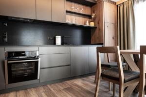 马兰扎ZI.INS Apartments的厨房配有不锈钢用具和桌椅