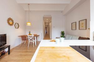 赫罗纳Bravissimo Riu Onyar的厨房以及带白色墙壁和木地板的客厅。