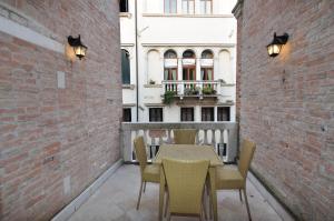 威尼斯卡萨德皮托利威尼斯公寓酒店的一个带桌椅的庭院和一座建筑