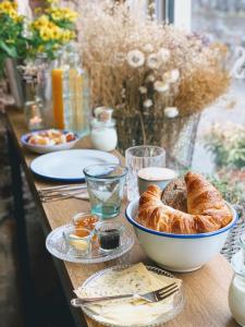 乌得勒支Logement Petit Beijers的桌子上放着一碗面包和其他食物