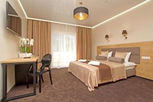 加茨比亚格拉Ośrodek Promenada- Horyzont的配有一张床和一张书桌的酒店客房