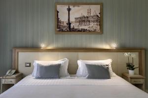 罗马澳大利亚多莫斯酒店的卧室配有一张带两个枕头的大白色床