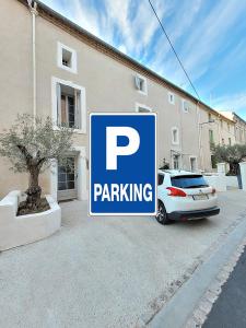 佩兹纳斯Maison 1634 - Centre historique, parking, petit-dejeuner compris, climatisation, piscine的停在大楼前的停车标志