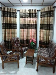 哈普特莱Mount View Family Rest & Cottage的客厅配有椅子、桌子和窗帘