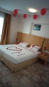 马斯喀特Al Reef Hotel的一间卧室配有一张红色装饰的床。