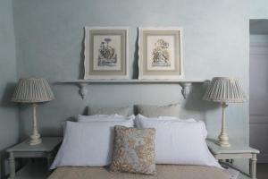 Borgomaro玛罗旅馆的一间卧室配有两盏灯和一张带白色枕头的床。